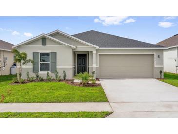 Charming single-story home with a well-manicured lawn, gray exterior, and a two-car garage at 1792 Aurora Oak Ln, Sanford, FL 32771