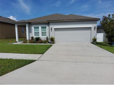 Charming one-story home with a well-manicured lawn and a two car garage at 881 Orchid Grove Blvd, Davenport, FL 33837