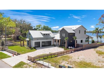 Beautiful waterfront home with a modern design, lush landscaping, and a private dock at 1340 Susannah Blvd, Orlando, FL 32803