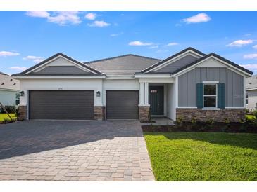 Charming single-story home boasts a three-car garage, paver driveway and stone accents at 2956 Arranmore Dr, Ormond Beach, FL 32174