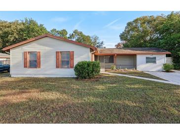 Ranch style home with brown shutters and a well-manicured lawn at 1748 Haverhill Dr, Deltona, FL 32725