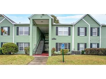Inviting two-story condo with a handicap parking sign, black shutters, and well-maintained landscaping at 2053 Dixie Belle Dr # 2053C, Orlando, FL 32812