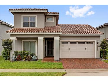 Charming two-story home featuring a well-maintained lawn and a stylish, two-car garage at 13007 Bromborough Dr, Orlando, FL 32832