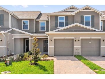Charming townhome featuring a two-car garage, lush lawn, and a welcoming entrance at 367 Sequoia Dr, Lake Wales, FL 33859