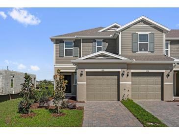 Charming two-story townhome with a well-maintained lawn and brick driveway at 410 Sequoia Dr, Lake Wales, FL 33859
