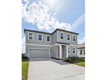 Charming two-story home featuring a two-car garage and manicured front lawn at 5714 Cattle Ranch Dr, St Cloud, FL 34771