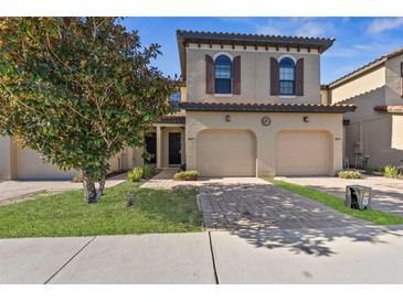 Two-story townhome with two-car garage and landscaped front yard at 8167 Roseville Rd, Davenport, FL 33896