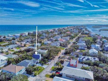 Beautiful aerial view of a coastal home with ocean access and lush tropical landscaping at 6353 River Rd, New Smyrna Beach, FL 32169