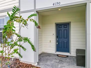 Charming home featuring a blue front door, covered entryway, and neatly landscaped surroundings at 4190 Lana Ave, Davenport, FL 33897