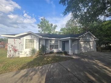 Charming single-story home featuring manicured landscaping and an attached two car garage at 713 Swan Way, Kissimmee, FL 34758
