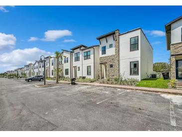 Street view of modern townhomes with sleek design, stone accents, and ample parking at 244 Villa Domani Cir, Davenport, FL 33896