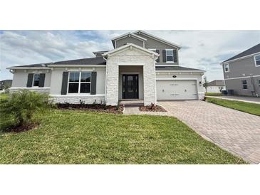 Charming two-story home with manicured lawn, stone accents, and a two-car garage at 987 Hawksnest Pt, Oviedo, FL 32765