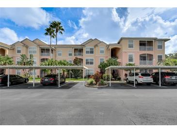 Exterior view of condo building with covered parking at 13560 Turtle Marsh Loop # 329, Orlando, FL 32837