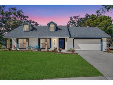 Charming single-story home featuring a well-manicured lawn and a classic brick-accented facade at 4034 Winderlakes Dr, Orlando, FL 32835