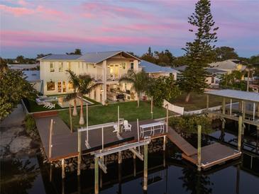 Stunning waterfront home features a private dock, pool, outdoor kitchen, and lush landscaping at 25 Cunningham Dr, New Smyrna Beach, FL 32168