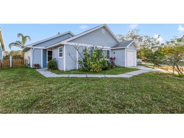 Cute blue house with a well-maintained lawn and a white picket fence at 250 Silas Phelps Ct, Orlando, FL 32828