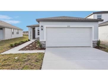New construction home exterior featuring a two-car garage and walkway at 2522 Linda Knoll Ln, Bartow, FL 33830