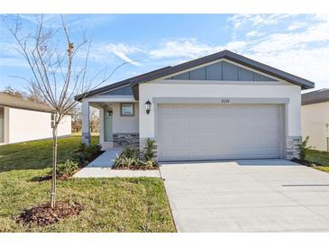 Newly constructed home with gray garage door and light-colored siding at 2538 Linda Knoll Ln, Bartow, FL 33830