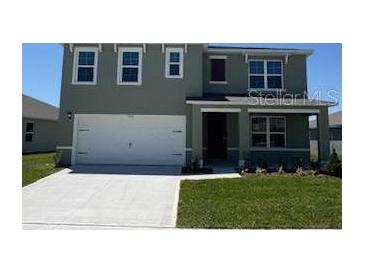 Charming two-story home boasts a large garage, well-manicured lawn, and inviting covered entryway at 3528 Sandalwood Isle Way, Ocoee, FL 34761