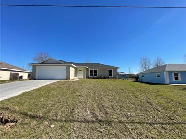 Newly constructed one-story home with a spacious front yard and attached garage at 199 Juniper Way, Ocala, FL 34472