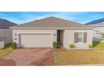 Charming single-story home featuring a brick driveway, attached garage, and well-maintained front yard at 473 Disa Dr, Davenport, FL 33837