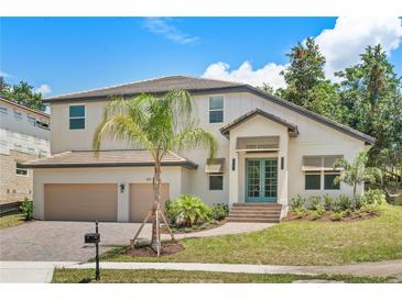 Two-story house with light-colored siding, light brown garage doors, and a landscaped yard at 531 Sanctuary Golf Pl, Apopka, FL 32712