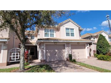 Charming townhome featuring a private garage and a meticulously maintained landscaped yard, offering curb appeal and convenience at 8343 Bella Tierra Ct # 8343, Davenport, FL 33896