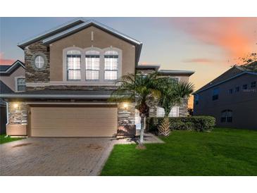 Two-story house with stone accents and a two-car garage at 2620 Sand Arbor Cir, Orlando, FL 32824