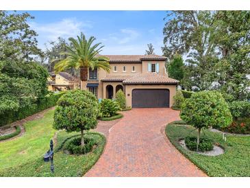 Two-story house with brick driveway, landscaping, and palm tree at 907 Moss Ln, Winter Park, FL 32789