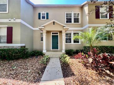 Inviting two-story home with lush landscaping and a charming entryway at 7128 Five Oaks Dr, Harmony, FL 34773