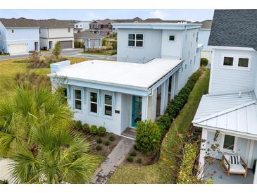 Modern two-story home with a light blue exterior and teal front door at 13104 Markowitz Aly, Orlando, FL 32827