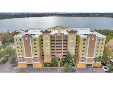 Beautiful waterfront condominium featuring a large building with lovely landscaping at 6336 Buford St # 705, Orlando, FL 32835