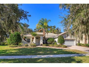 Single-story home with tile roof, landscaping, and attached garage at 1441 Beacon Dr, Kissimmee, FL 34746