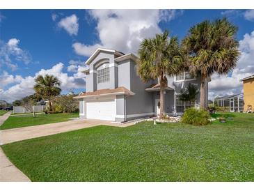 Charming two-story home features a well-manicured lawn, palm trees, and attached two-car garage at 3279 Fairfield Dr, Kissimmee, FL 34743