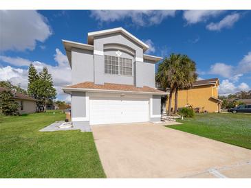 Two-story house with gray siding, white garage door, and palm trees at 3279 Fairfield Dr, Kissimmee, FL 34743