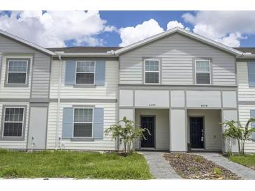 Charming townhome with blue shutters, manicured lawn, and welcoming front entrance at 4294 Lana Ave, Davenport, FL 33897