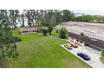 Aerial view of property showing large yard, 3 parked cars, and proximity to lake and development at 11326 Westwood Blvd, Orlando, FL 32821