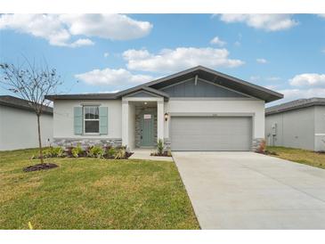One-story home with gray siding, light stone accents, and a two-car garage at 2121 Rosewood Dr, Bartow, FL 33830