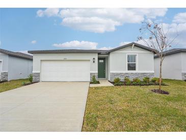 One-story house with a two-car garage, green door, and stone accents at 2125 Rosewood Dr, Bartow, FL 33830