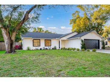 Charming single-story home nestled on a spacious lot with a lush lawn and mature trees at 1704 Ison Ln, Ocoee, FL 34761