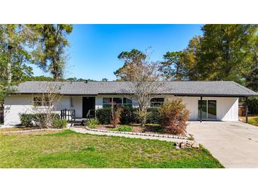 Charming single-story home featuring a white brick facade, landscaped front yard and a welcoming entrance at 4317 Ne 12Th St, Ocala, FL 34470