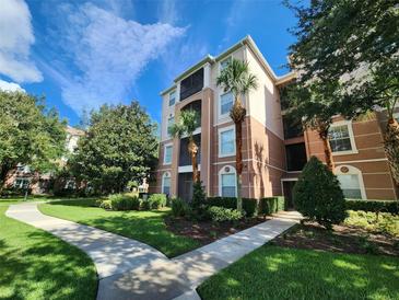 Exterior view of a three-story condo building with palm trees and landscaped grounds at 8306 Portofino Dr # 103, Davenport, FL 33896