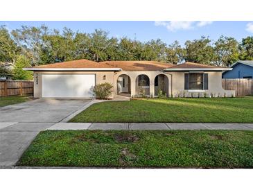 Ranch-style home with attached garage and well-manicured lawn at 1422 Tierra Cir, Winter Park, FL 32792