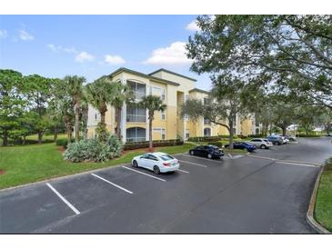 Condo building with parking lot and landscaping at 8817 Dunes Ct # 203, Kissimmee, FL 34747