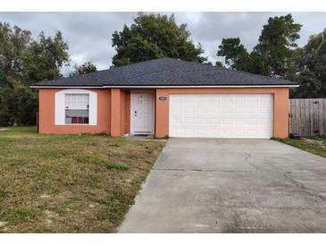 Orange house with white garage door and landscaped lawn at 1009 Fort Smith Blvd, Deltona, FL 32725