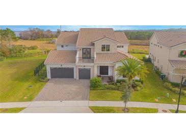 Beautiful two-story home with a two car garage, brick driveway, balcony, and well-manicured lawn at 13779 Abberwick Dr, Orlando, FL 32832