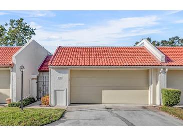 Tan colored house with red tile roof and attached garage at 218 Balfour Dr # 12, Winter Park, FL 32792