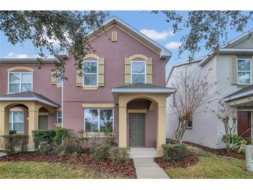 Two-story townhome with neutral exterior and landscaping at 7474 Bentonshire Ave, Windermere, FL 34786