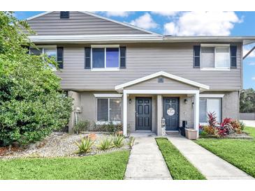 Tan two-story townhome with 2 front doors, landscaping, and walkway at 113 Kristi Ann Ct # 113, Winter Springs, FL 32708