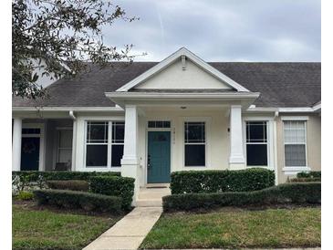 Charming single-story home with teal door and manicured landscaping at 14176 Orchid Tree Pl, Orlando, FL 32828